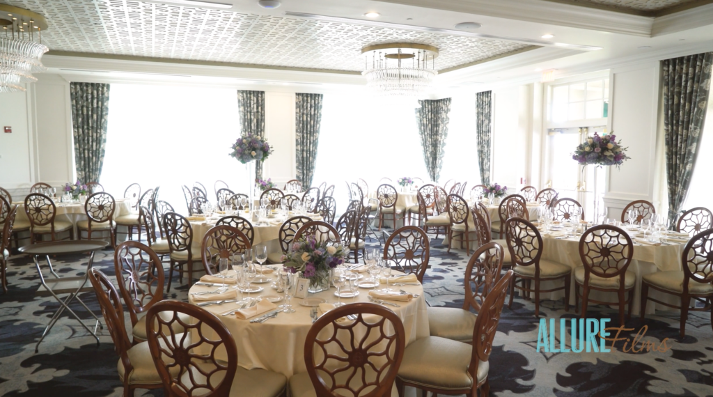 Inside the Overbrook Golf Club Ballroom before the celebration. The room is brightly lit and filled with round tables and chairs nicely decorated awaiting guests arrival.